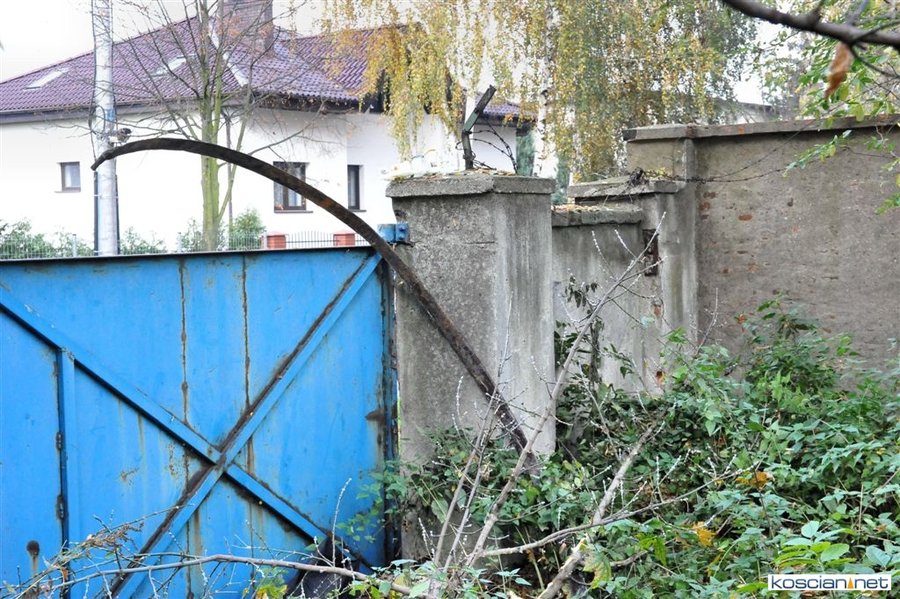 Metalowa obręcz uszkodziła uliczną lampę i drzewo. Jej cześć zawisła na bramie