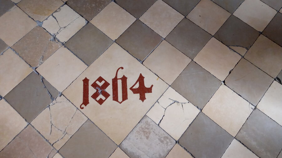 Płytka z posadzki fary z zaznaczonym rokiem, który oznacza likwidację posadzki ceglanej. Fot. Teresa Masłowska   