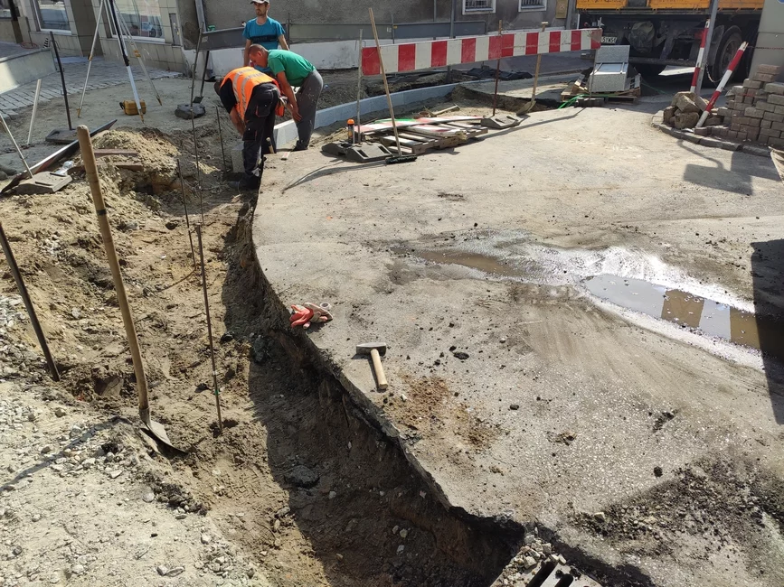 Trwa układanie krawężnika wyznaczającego granicę płyty Rynku.   